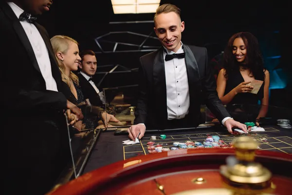 A woman in a luxurious green gown next to an ornate roulette wheel, capturing the upscale casino mood of BEFWAY.