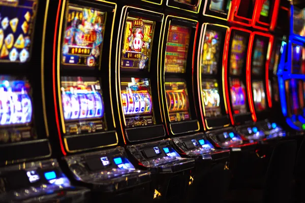 A woman smiling by bright slot machines showing lucky symbols, showcasing the exciting slot offerings at BEFWAY.